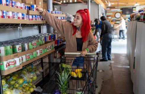 a young woman with red hair shops for food at a pantry