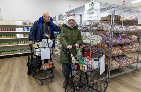 Two people shop at a food pantry.