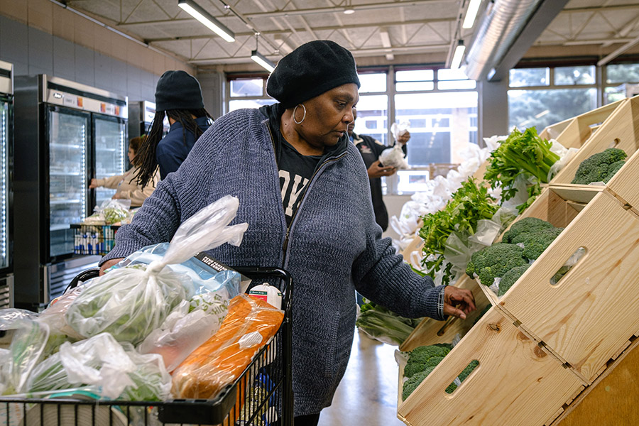 a woman shops for produce at a food pantry