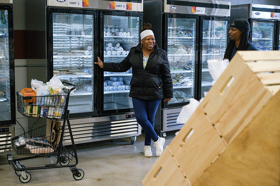 a woman pauses during a grocery shopping trip