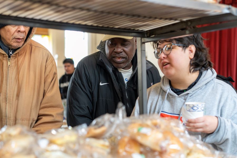 a volunteer helps pantry guests