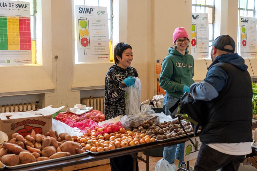 volunteers assist a food pantry guest