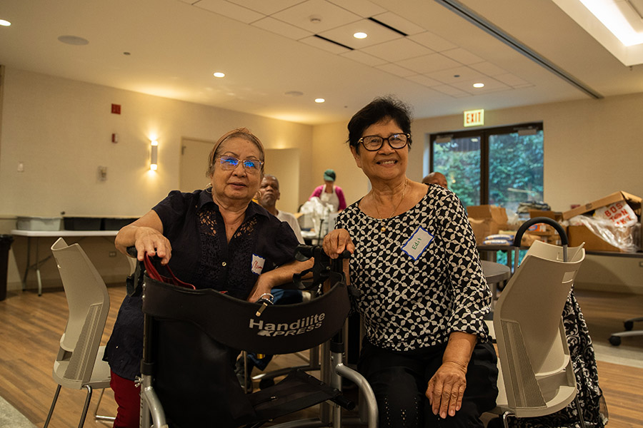 two women sitting at dinner smile at the camera