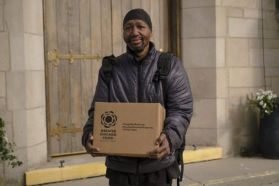 a man holding a food box looks at the camera