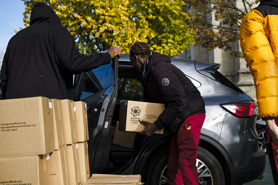 A man puts a food box in the backseat of a car