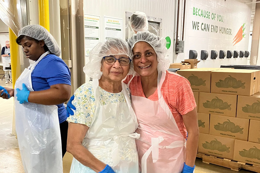 A mother and daughter pause during volunteering to smile at the camera