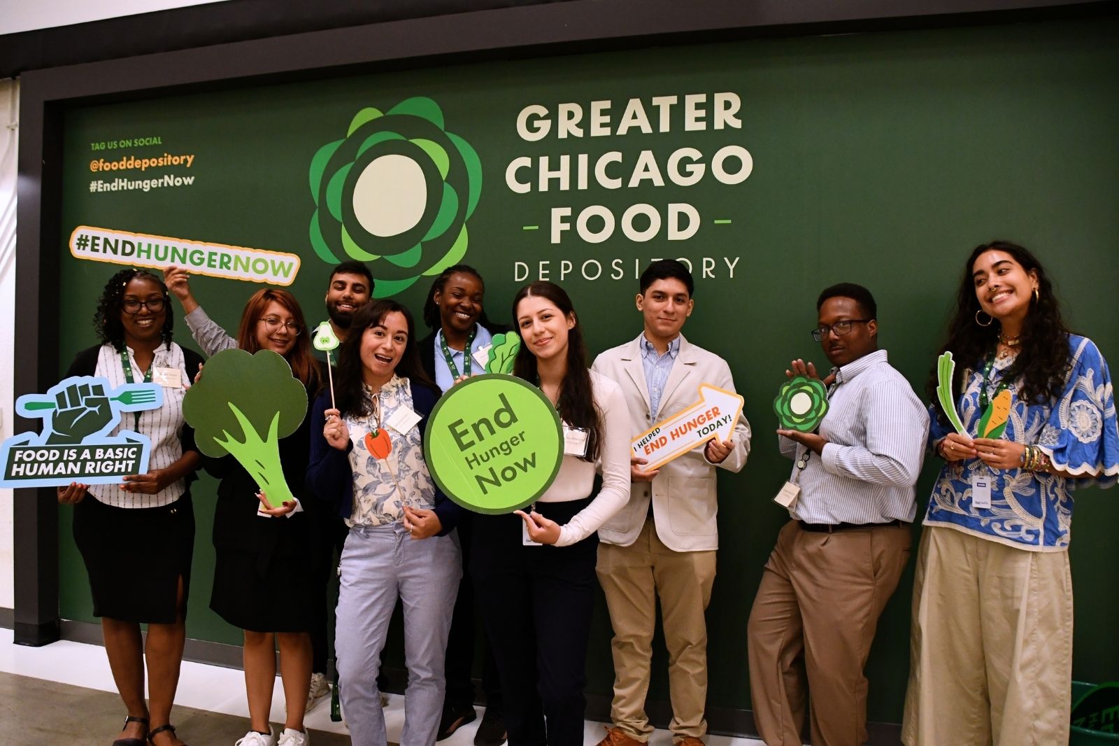 Group picture of people holding end hunger signs in front of a Greater Chicago Food Depository Logo.